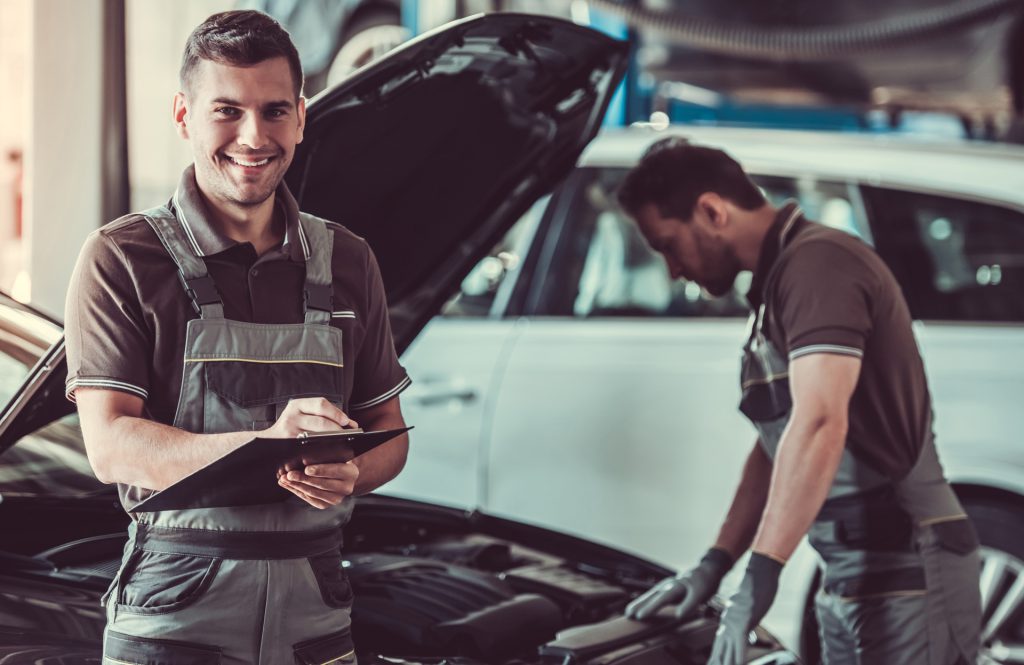 Two mechanics looking over a website - MOT & Servicing Derby