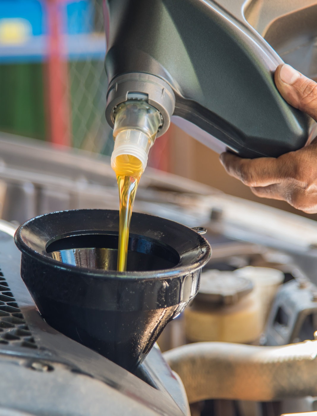 Mechanic pouring engine oil into a vehicle - Car Servicing Derby